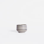 Handmade espresso cup featuring a matte marble finish in natural earthy hues, set against a white background.