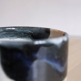 The intricate interior detail of a handcrafted ceramic cup, featuring a captivating midnight blue and white finish.