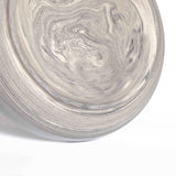 Vertically positioned inverted handcrafted pasta plate, featuring a marbled bottom, against a white background.