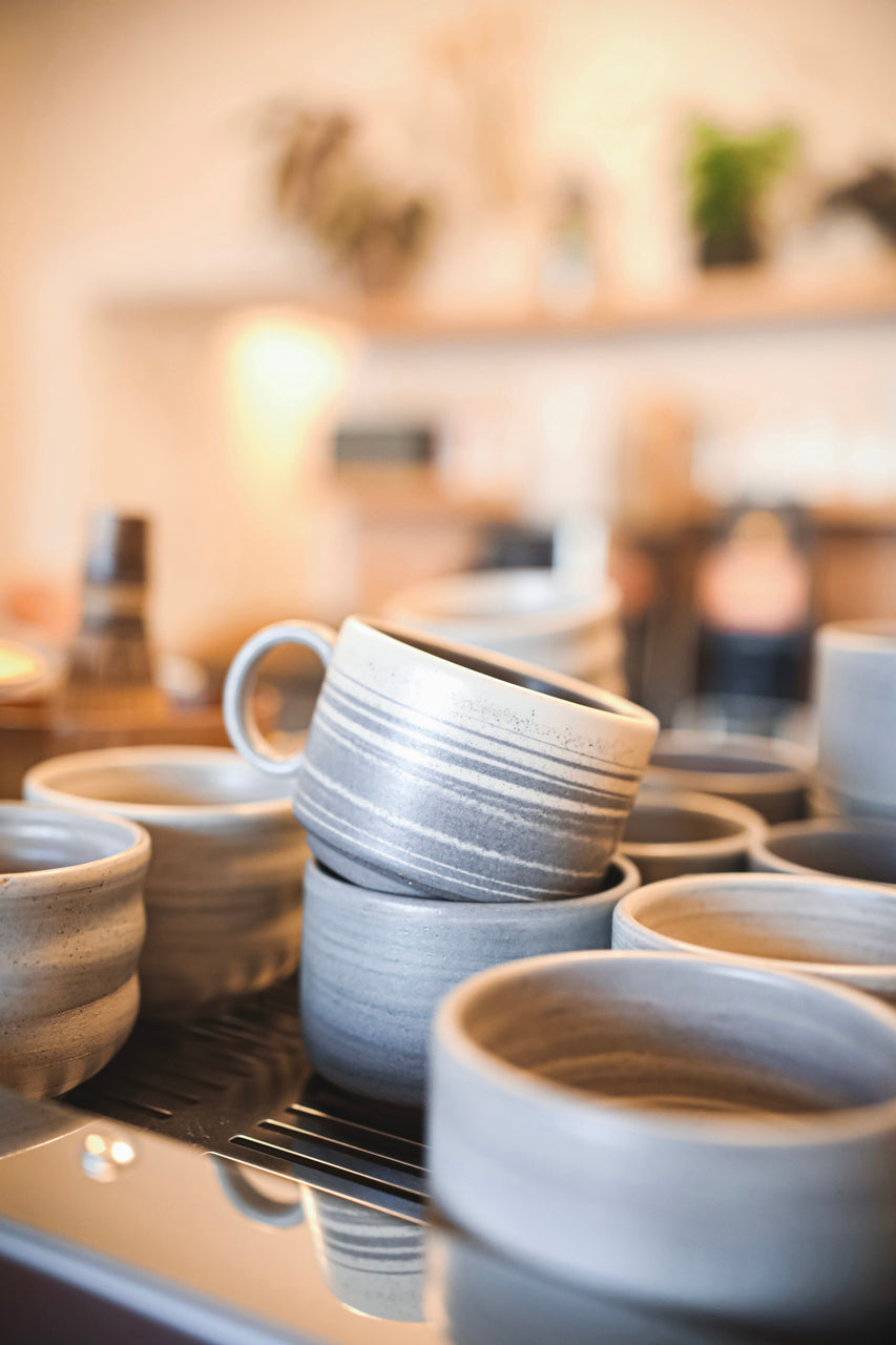 Coffee cups stacked atop a coffee machine.