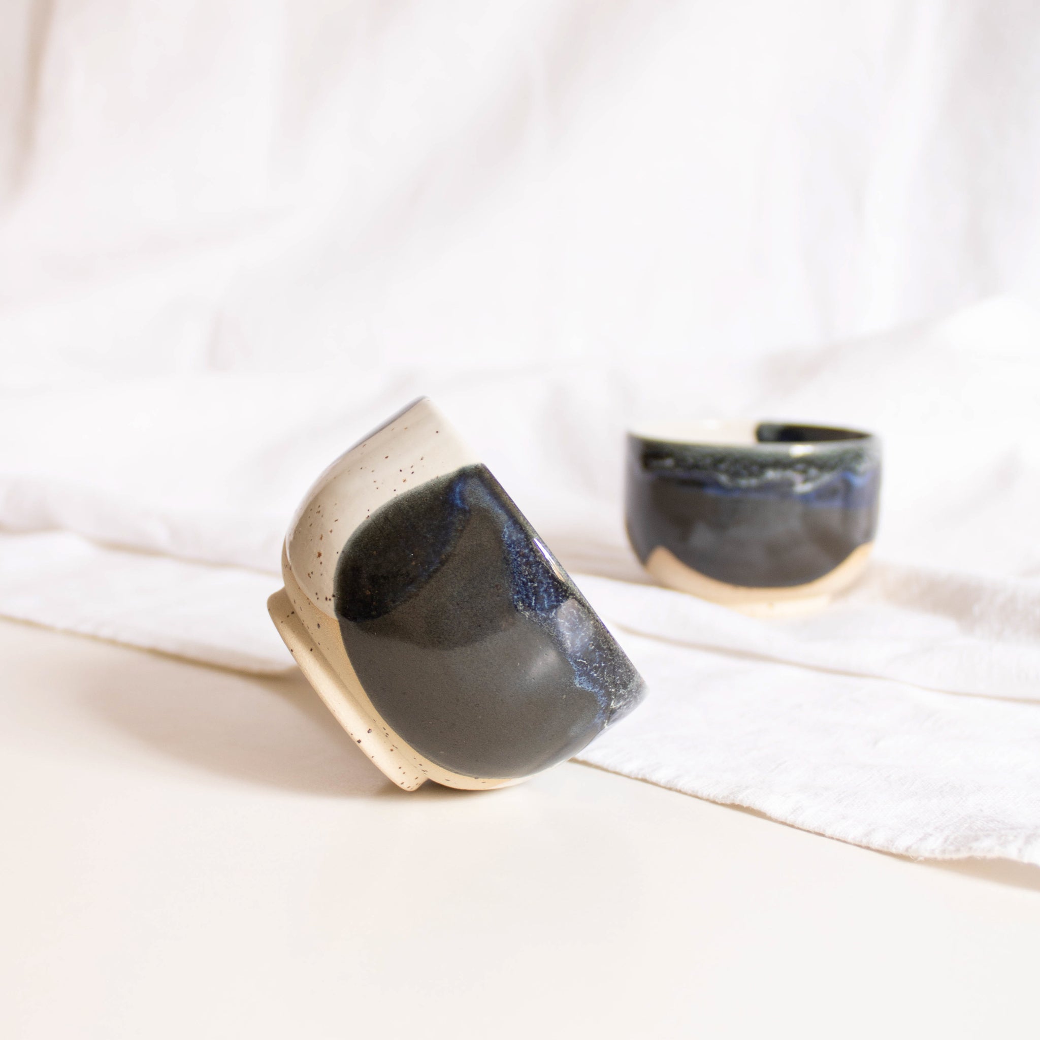 Close-up of a handcrafted ceramic cappuccino cups, showcasing a captivating midnight blue and white finish.