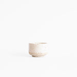 A handcrafted ceramic espresso cup in speckled white finish, set on a white background.