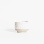 A handcrafted ceramic cappuccino cup in speckled white finish, set on a white background.