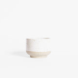 A handcrafted ceramic cappuccino cup in speckled white finish, set on a white background.