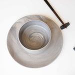 A set of handcrafted marbled ceramic plate, bowl, and chopsticks arranged neatly on a white surface.