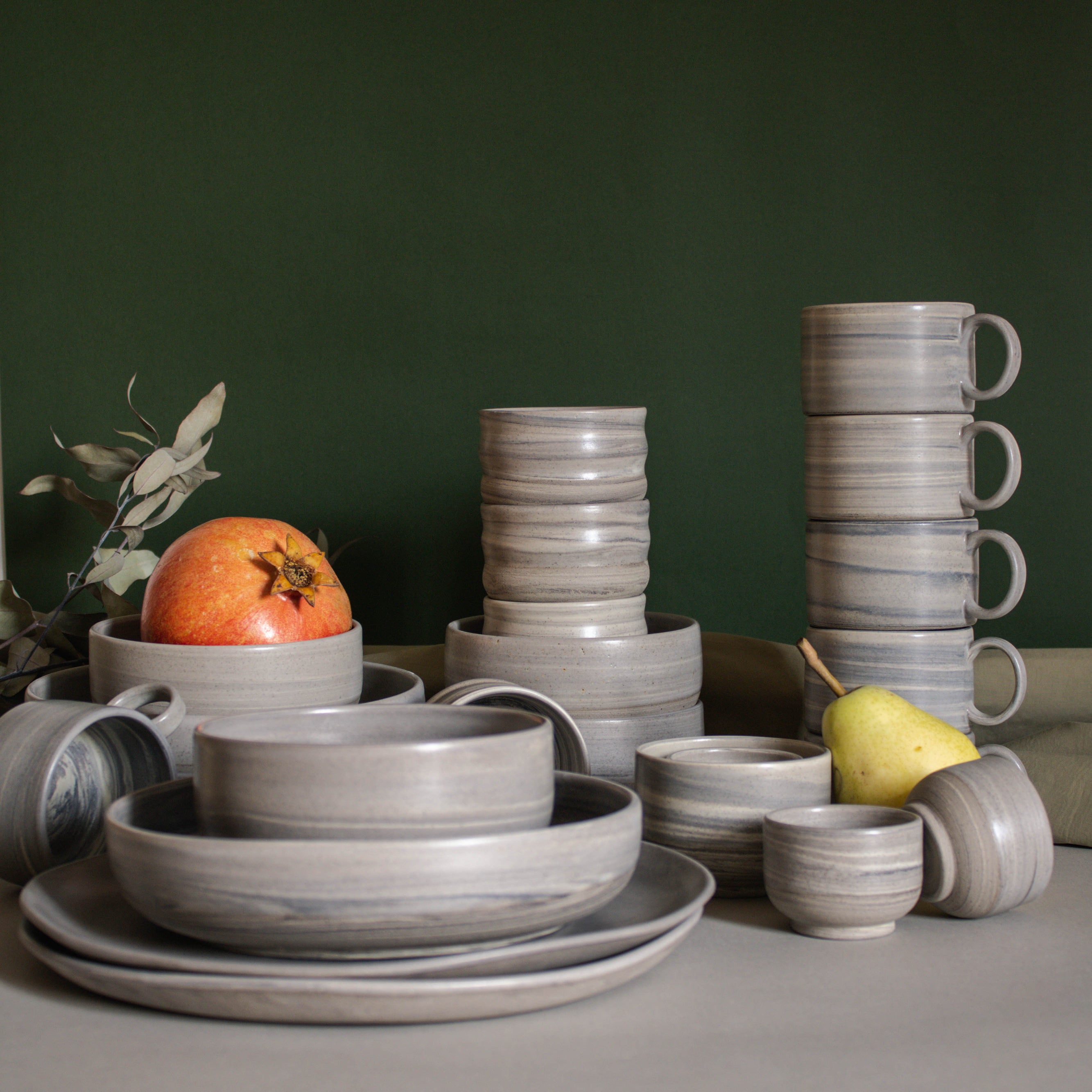 Table arrangement of various handmade ceramics in earthy tones.